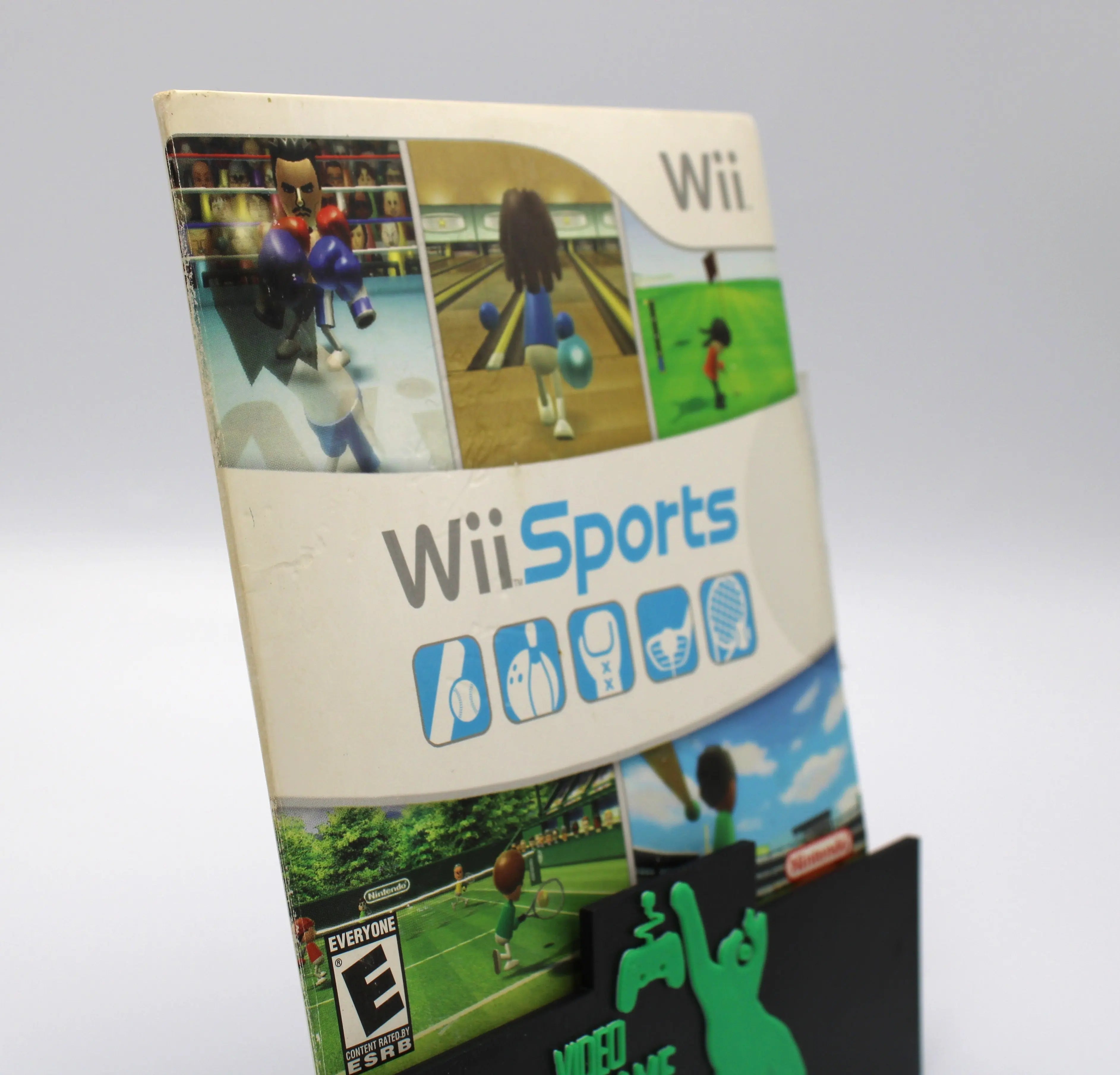Side angled view of a 2006 authentic NTSC-U copy of Wii Sports for Nintendo Wii in cardboard sleeve displayed against a clean white background. Highlighting minor shelf wear and light discoloration to cardboard sleeve case from use and age.