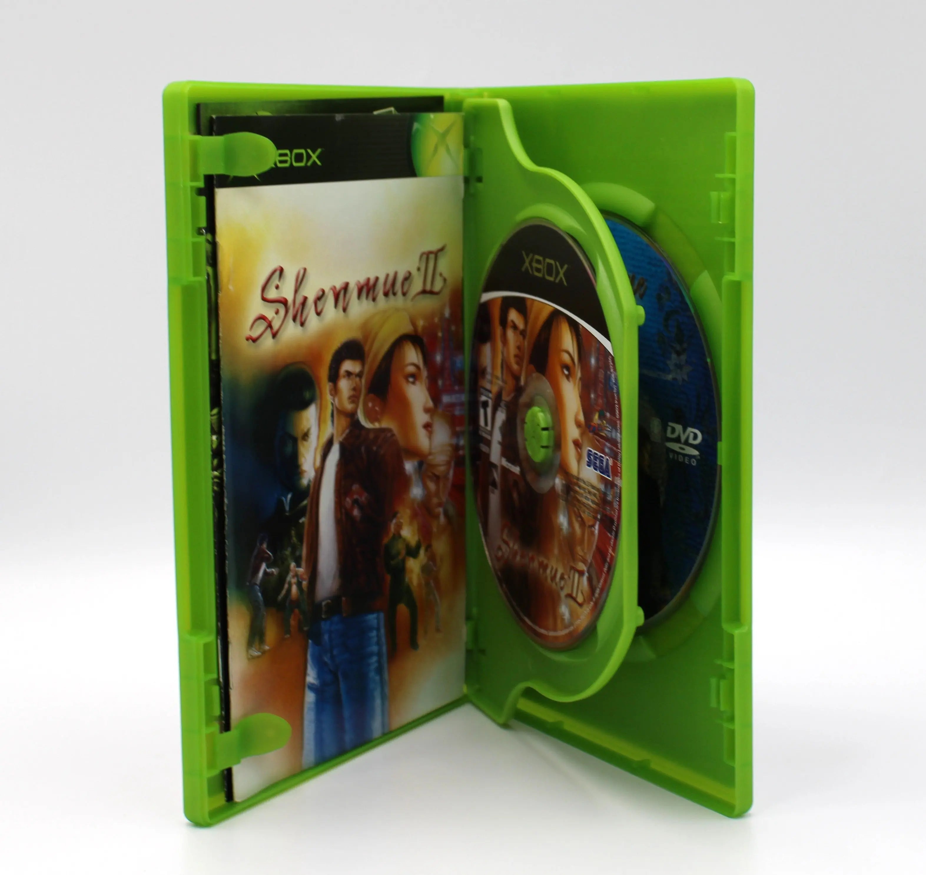 Open case view of Shenmue II for Microsoft Xbox Original NTSC-U, showing manual placement and both discs secured in trays.