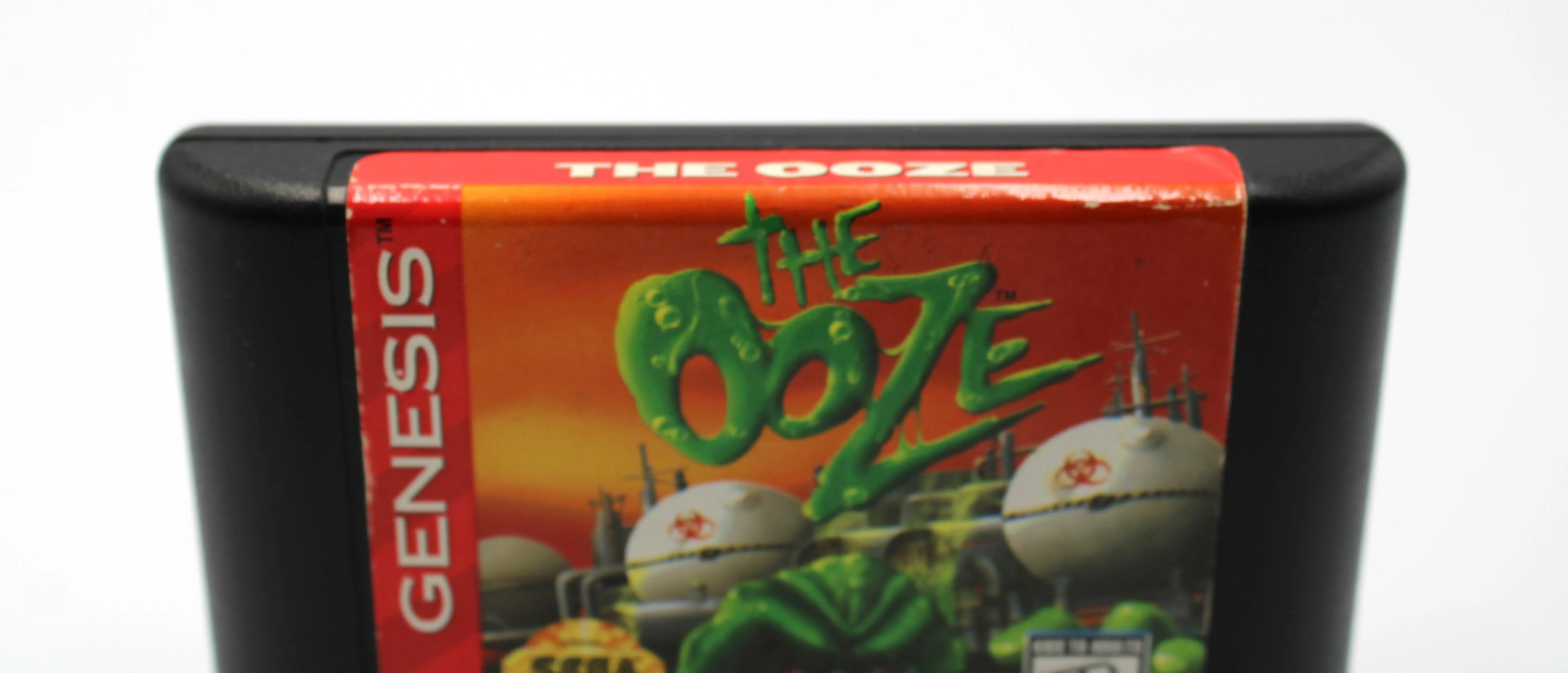 See up close label view for The Ooze for Sega Genesis. 1995. NTSC-U Authentic Video Game Cartridge. See picture of authentic cartridge minor wear to top label.