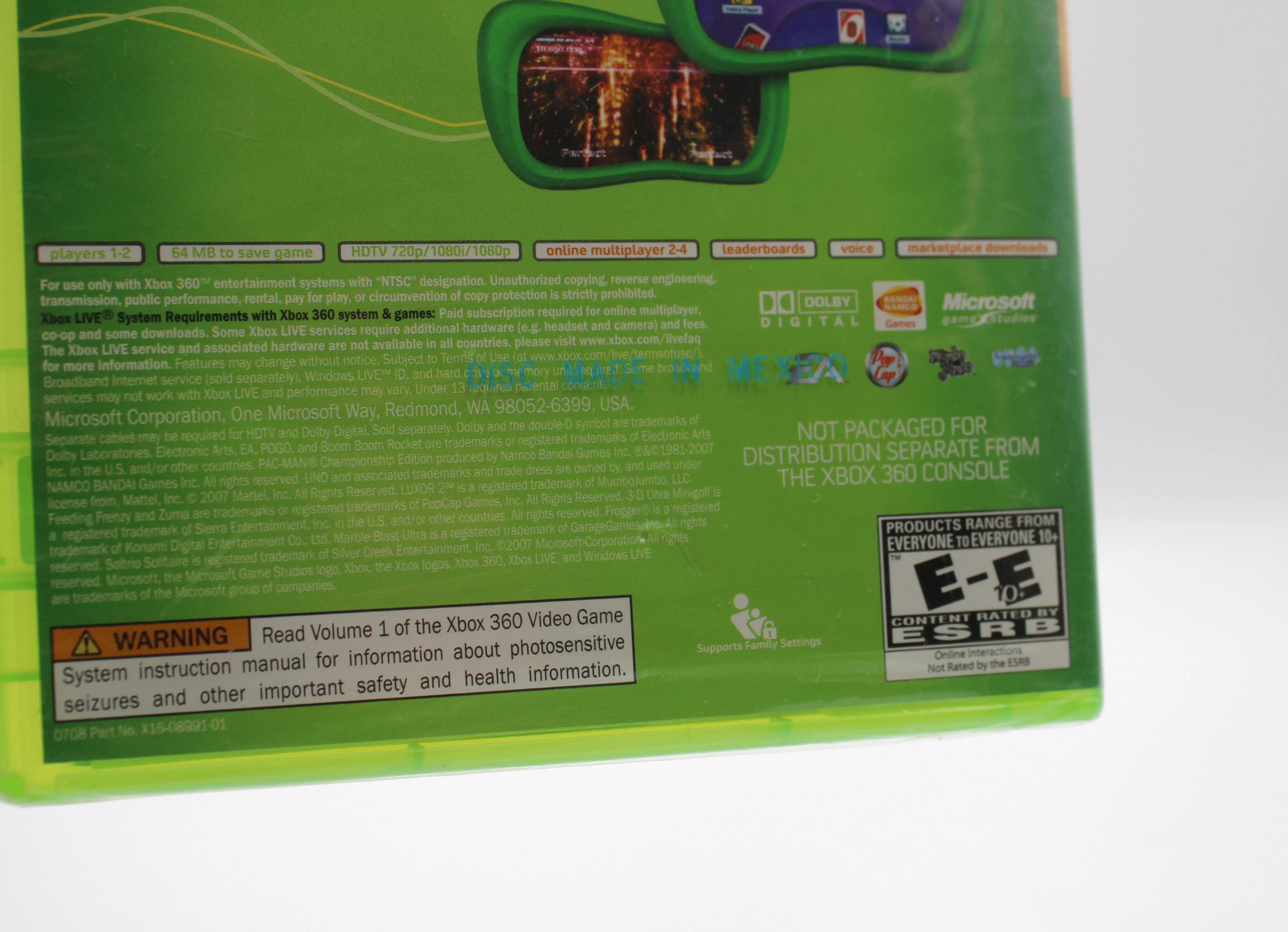 Close up view of Sega Superstars Tennis & Arcade Compilation for Microsoft Xbox 360 NTSC-U sealed game case, showing tear to bottom middle of back of case.
