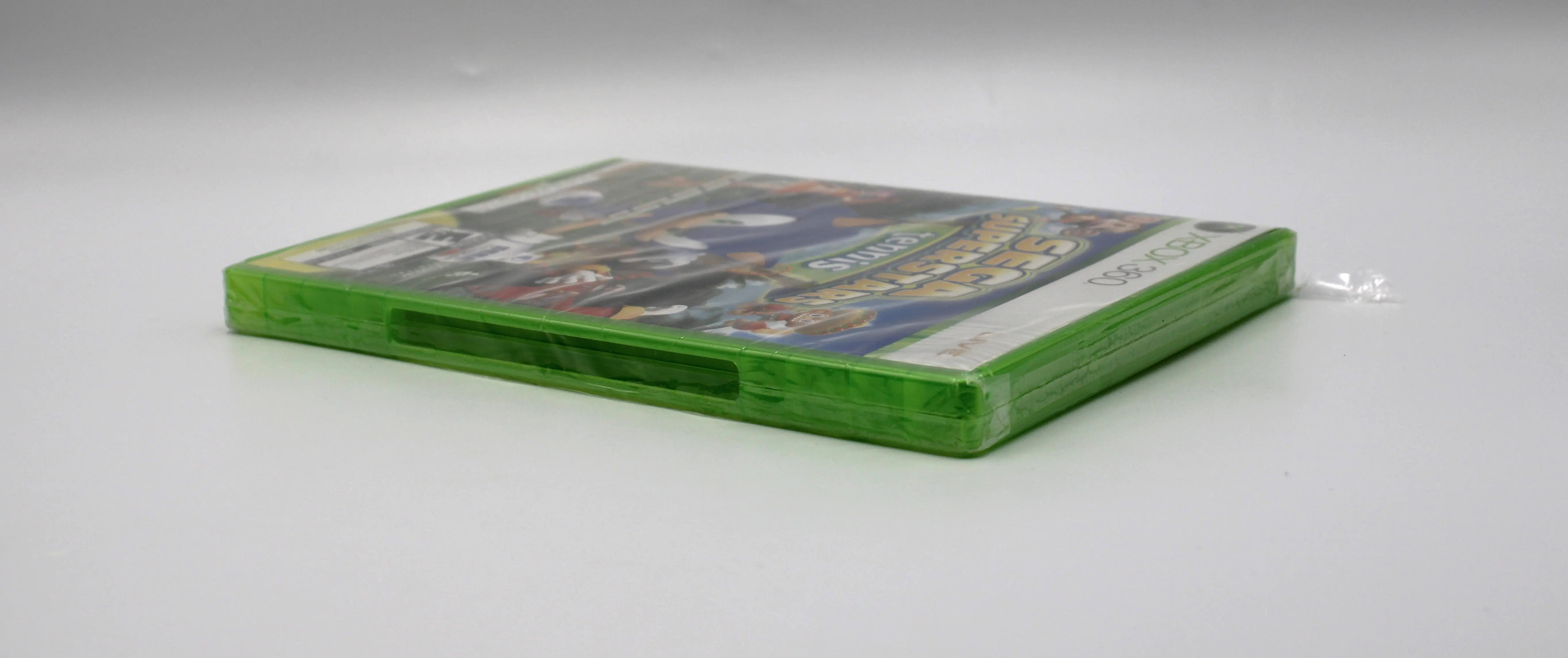 Side case view of Sega Superstars Tennis & Arcade Compilation for Microsoft Xbox 360 NTSC-U sealed game case, showing case opening seal and tear to corner.