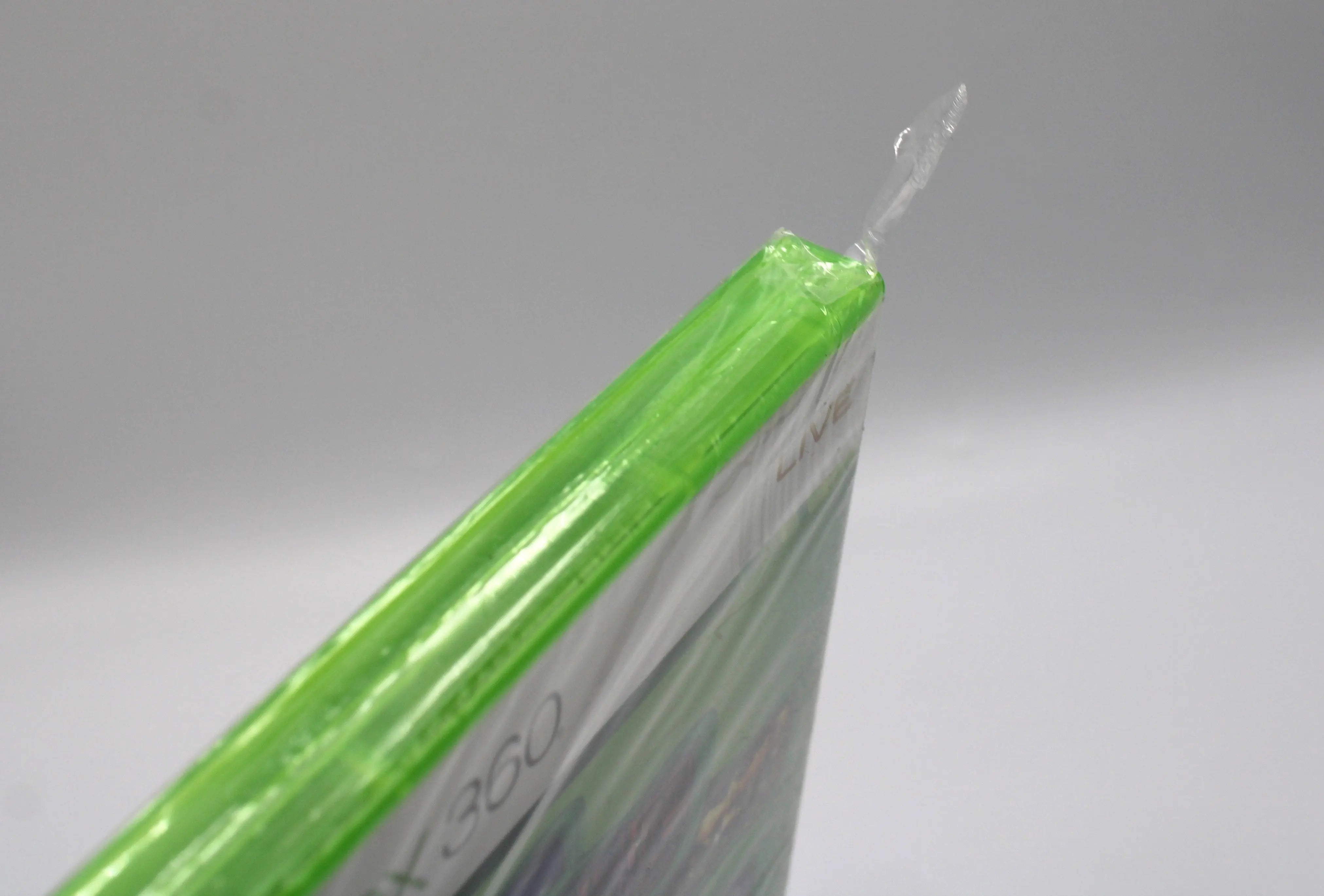 Close up view of Sega Superstars Tennis & Arcade Compilation for Microsoft Xbox 360 NTSC-U sealed game case, showing tear to top corner.