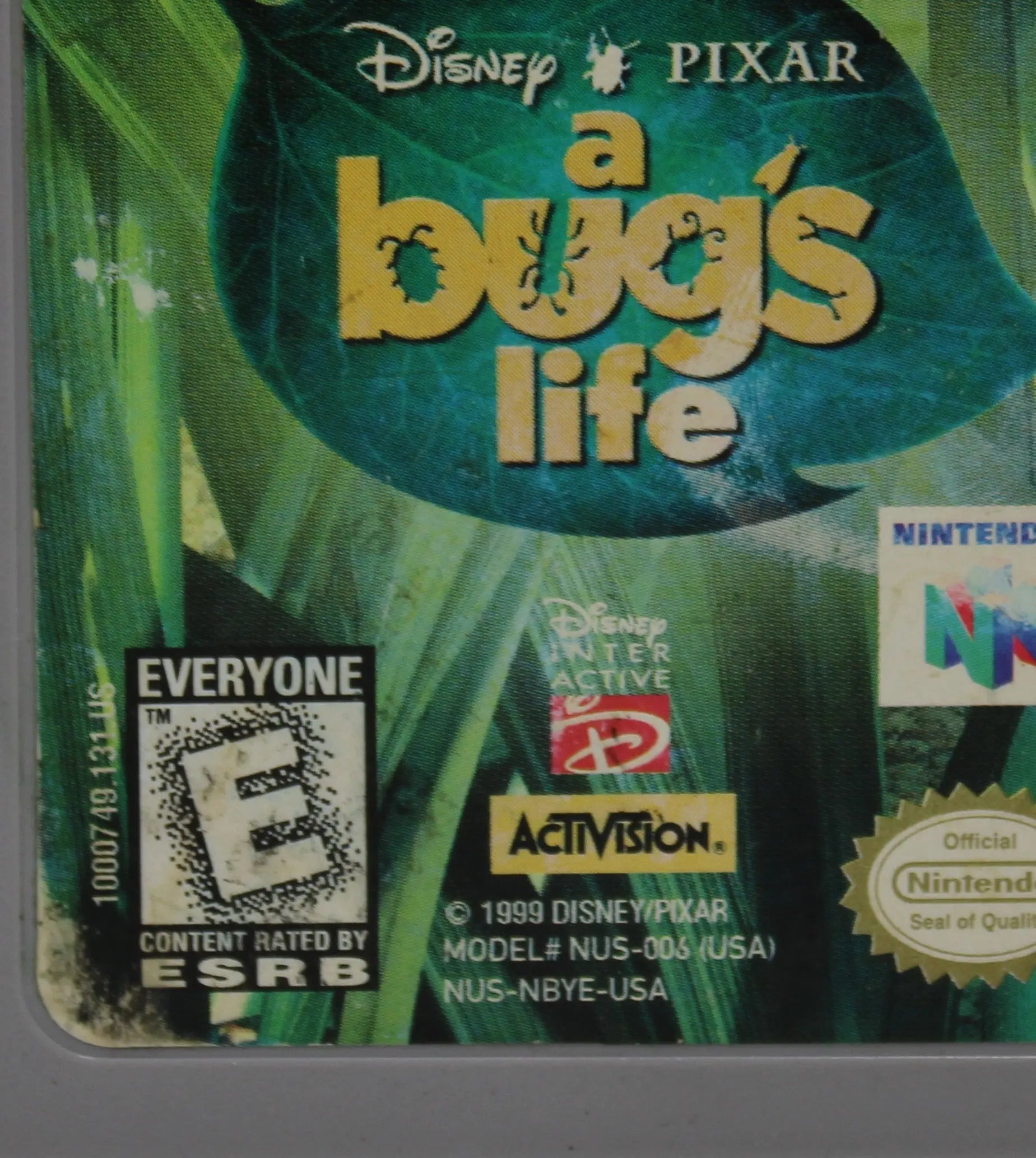 Up close front label view of NTSC-U copy of Disney's A Bug's Life for Nintendo 64, N64. Released in 1999. See picture of wear to front label and black staining over ESRB E rating and overall condition.