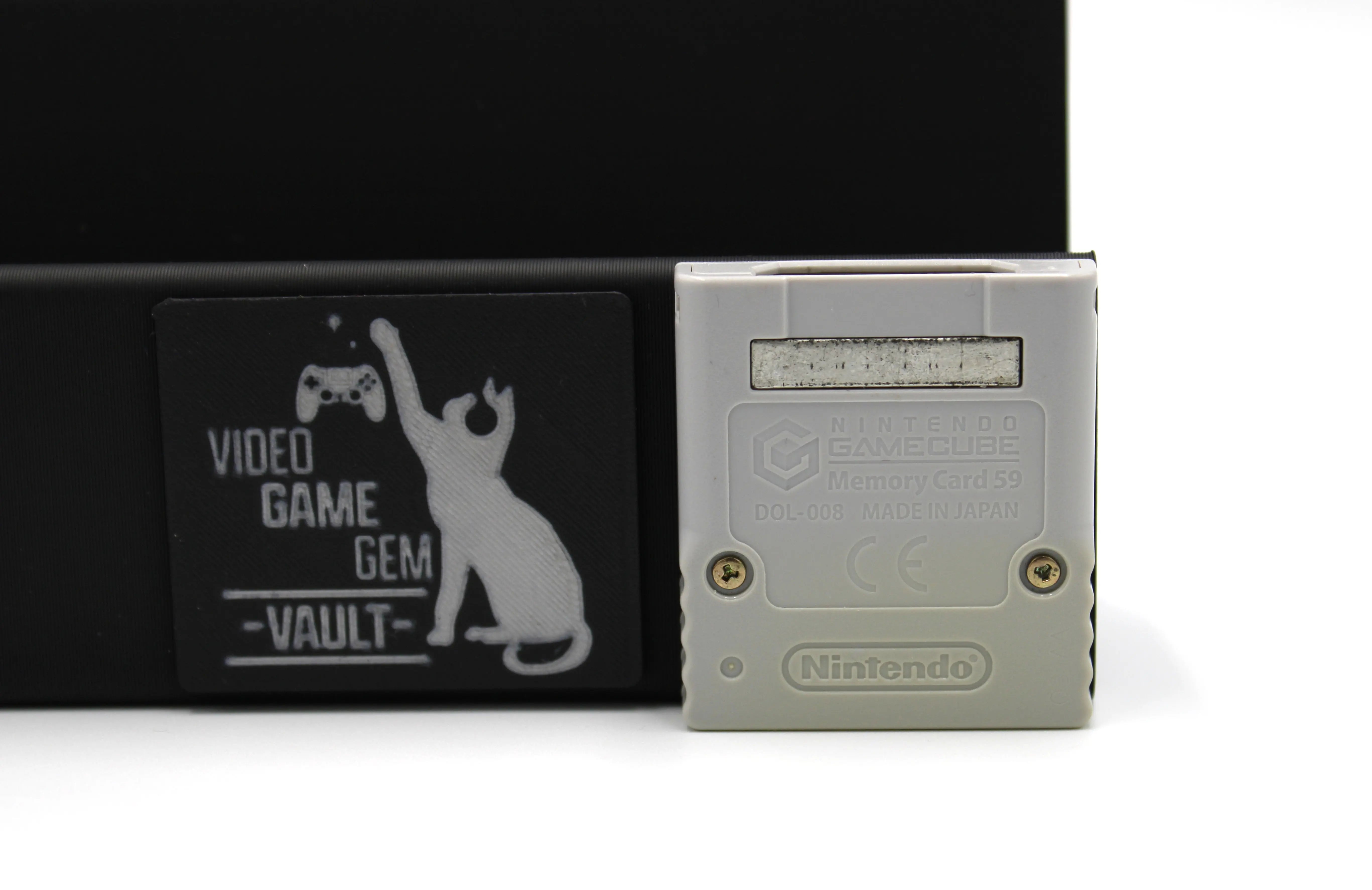 Back image of 2002 released NTSC-U of OEM Animal Crossing Memory Card for Nintendo GameCube – 59 Blocks (DOL-008). Displaying authentic grey Animal Crossing memory card back with Made in Japan and other gaming text with minor discoloration to the bottom of the cartridge on a clean white background.