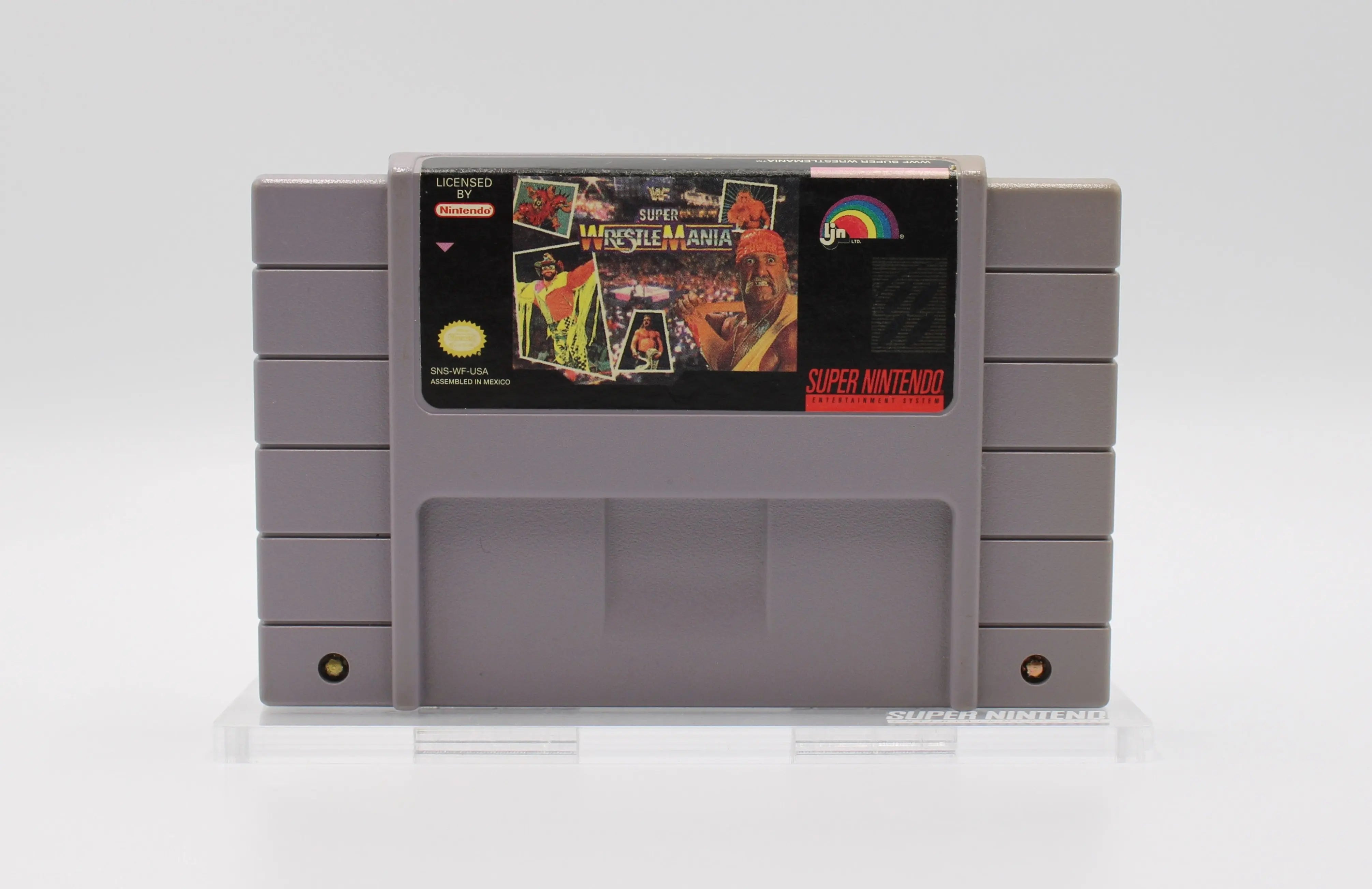 Front cartridge view of retro SNES game WWF Super WrestleMania. See picture of front label of the NTSC-U cartridge with title text and game characters - Hulk Hogan and more.