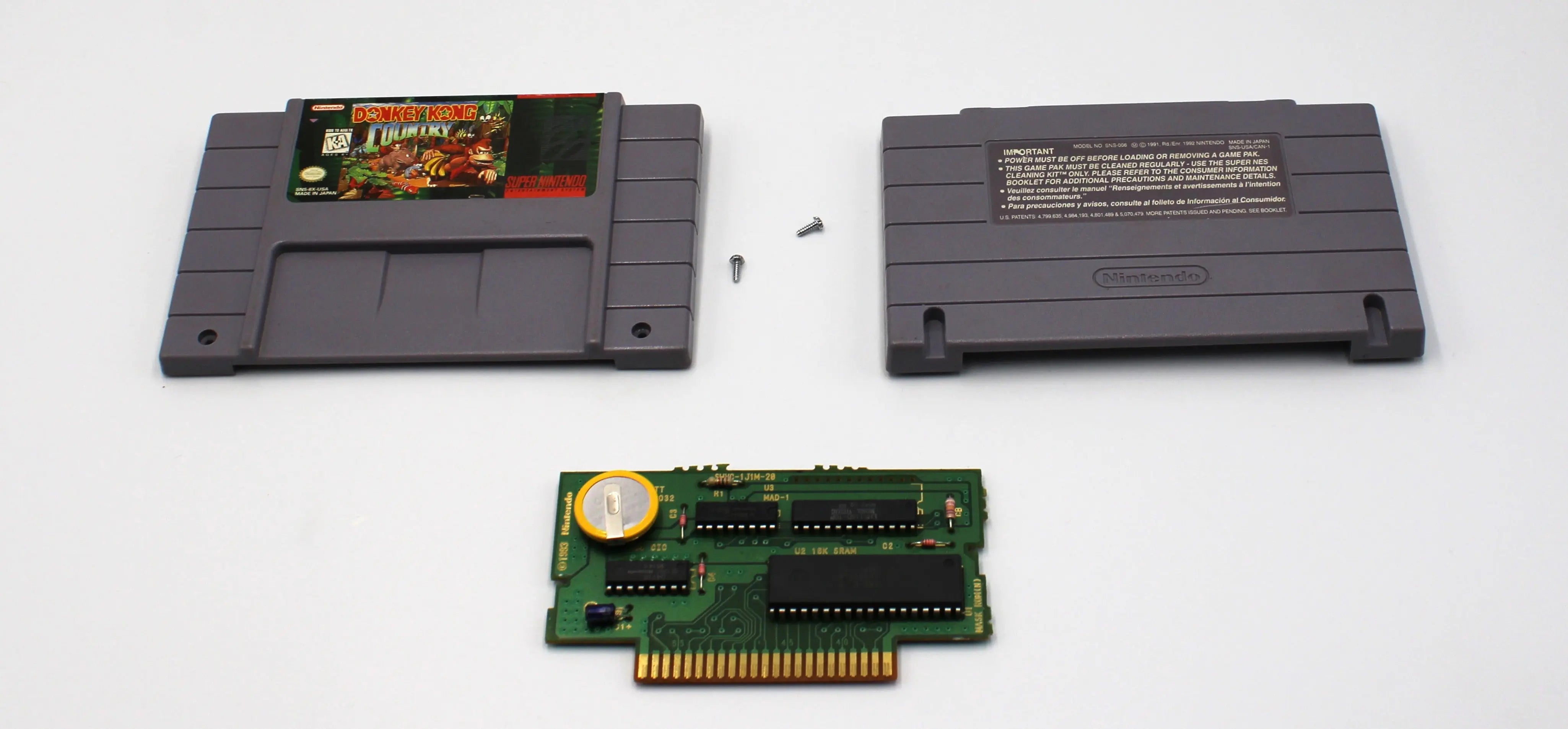 Main display of Donkey Kong Country for Super Nintendo SNES – Authentic Game Cartridge, New Save Battery (1994) NTSC‑U. Includes front and back shell, board, security screw, and the new internal save battery, shown fully disassembled for authenticity verification.