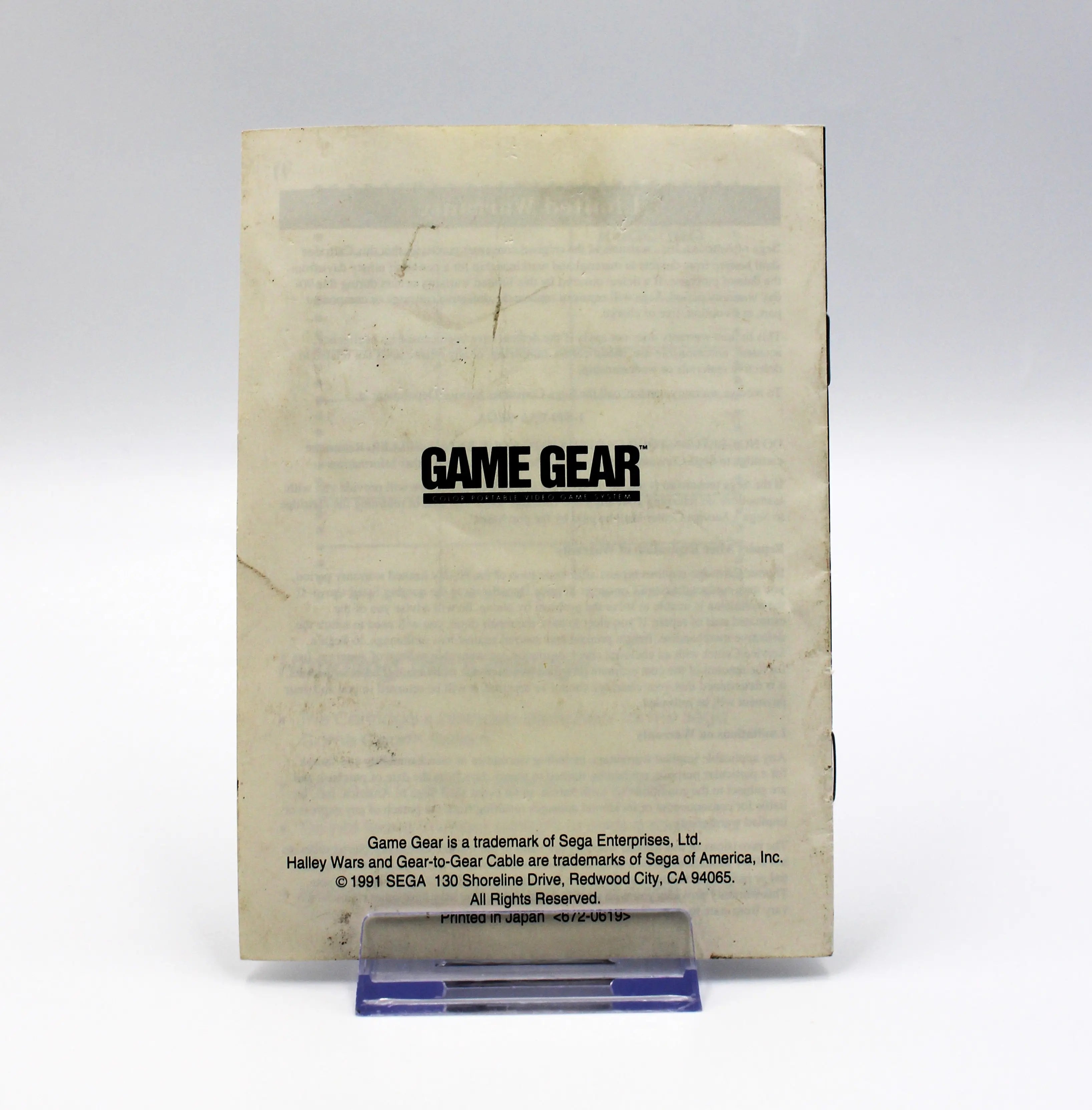 Back of Halley Wars manual, displaying Sega Game Gear title text and rights reserved against a white background. View of some cosmetic wear such as stains and scuffs from age.