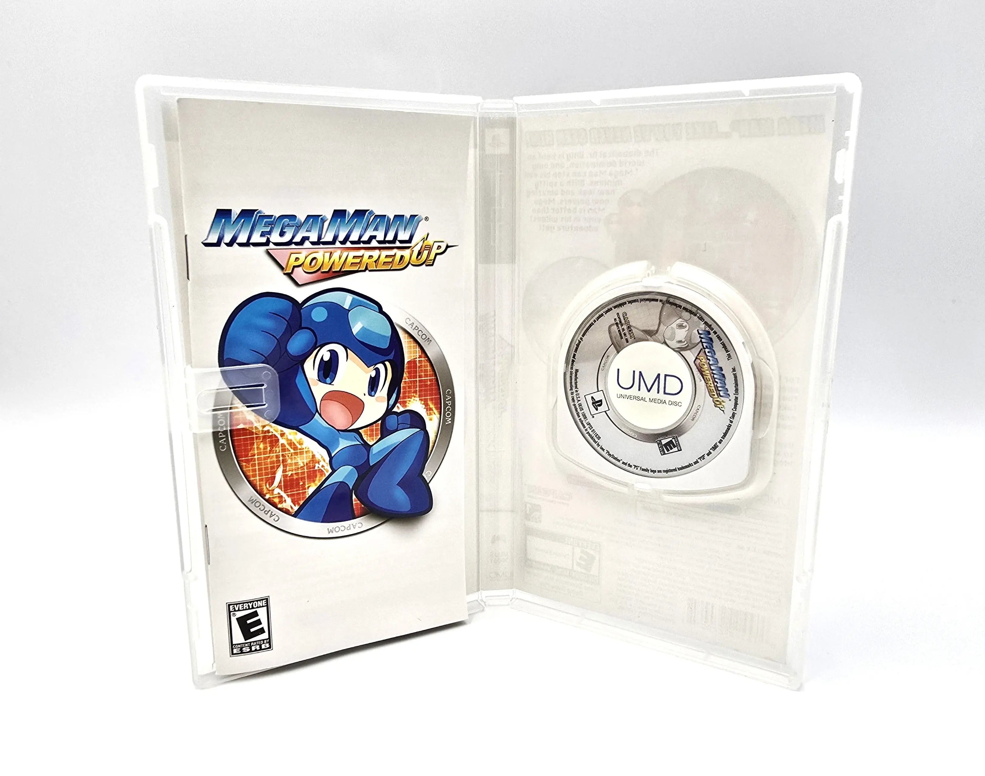 Open case view of Mega Man Powered Up for Sony PlayStation Portable PSP (2006) NTSC-U, showing manual on the left and UMD disc on the right.