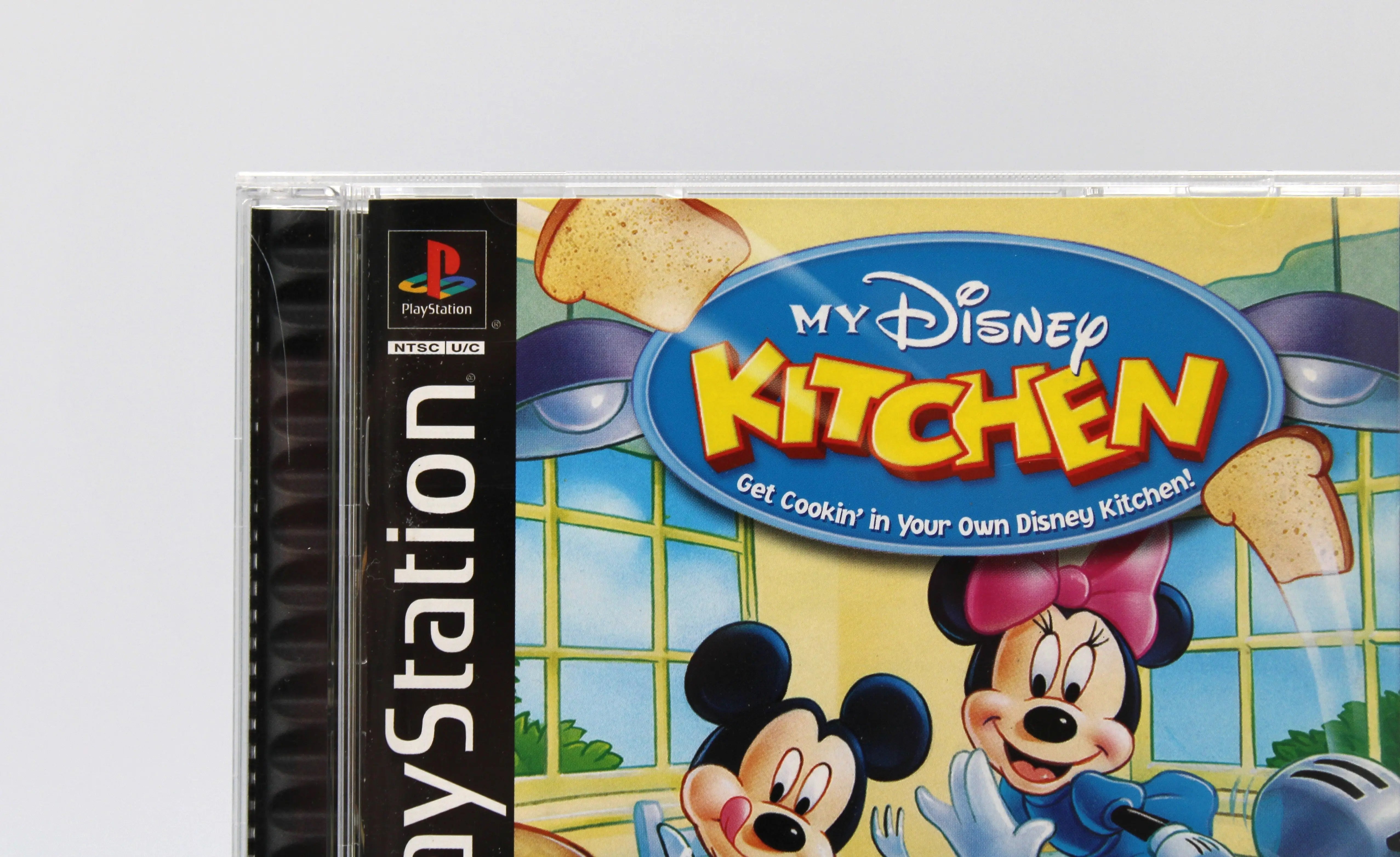 View of black label NTSC-U CIB copy of My Disney Kitchen for Sony PlayStation 1, PS1. Video game. See picture of small crack to top left of front of case.