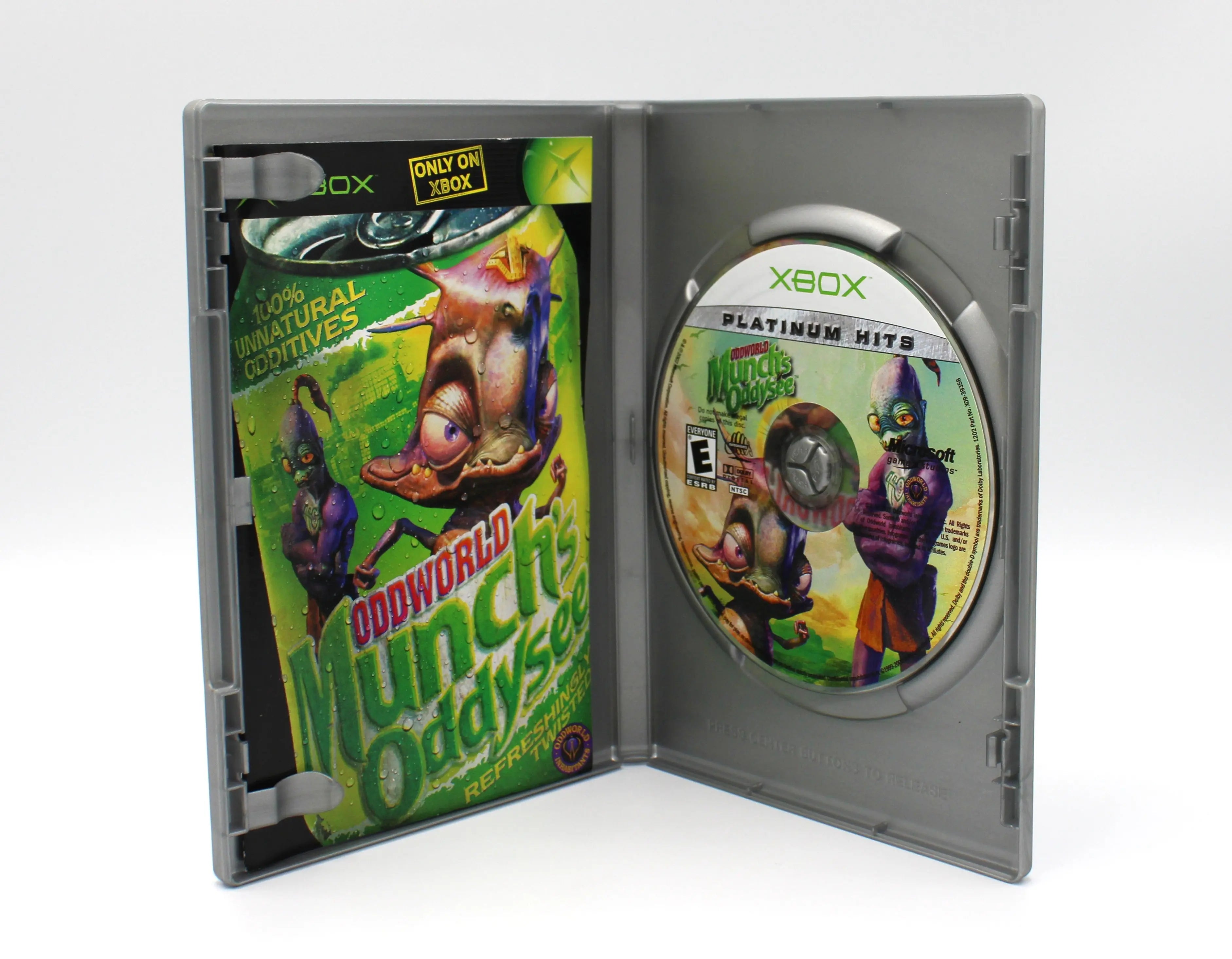 Opened case of Oddworld: Munch’s Oddysee Platinum Hits for Microsoft Xbox Original – CIB with Manual (2001) NTSC‑U, displaying the manual inserted in its sleeve and the disc on the spindle beneath the Platinum Hits branding.