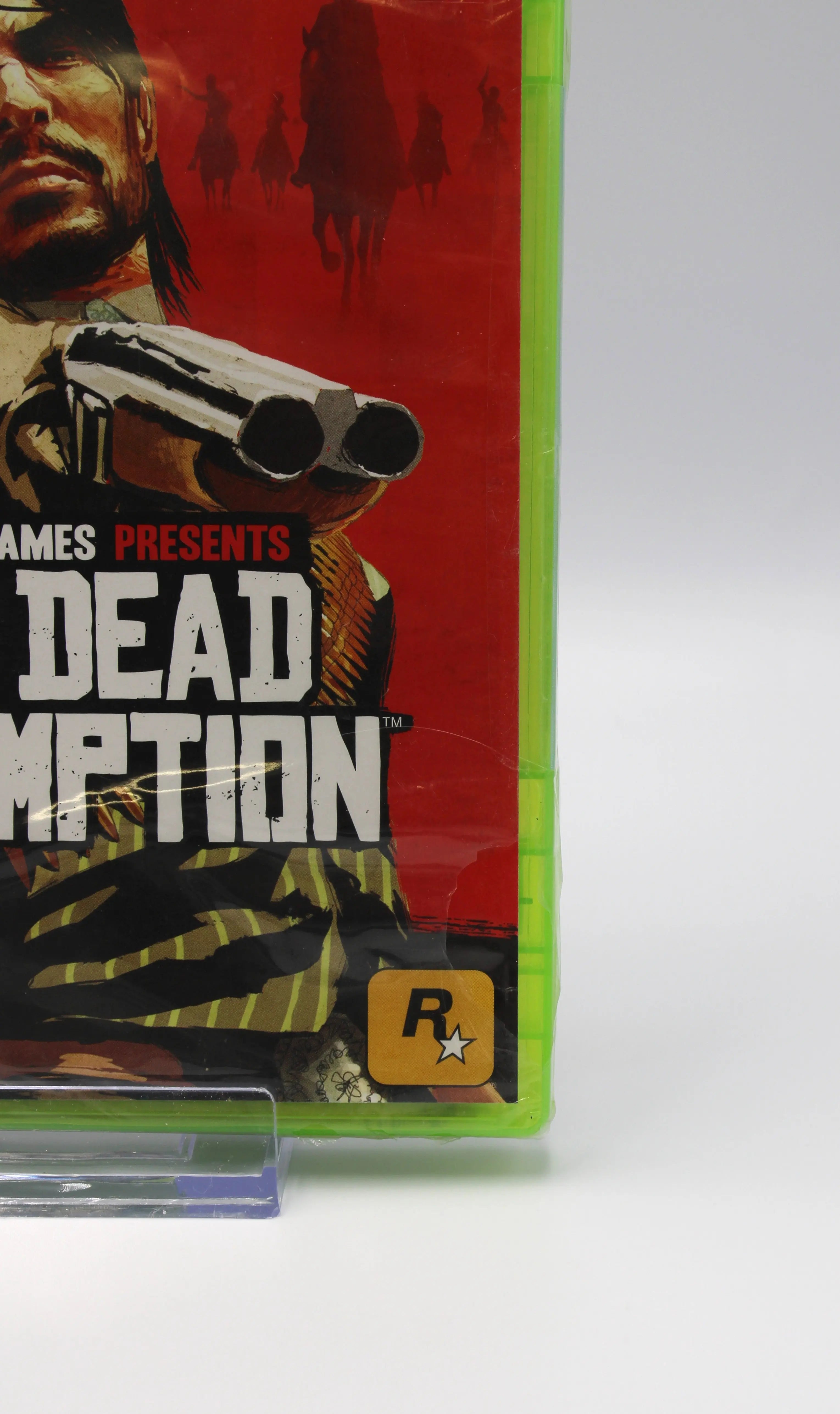 Front right view of Red Dead Redemption for Microsoft Xbox 360 NTSC-U sealed Platinum Hits game case, showing tear by Rockstar logo to the bottom right of front of authentic game case seal.