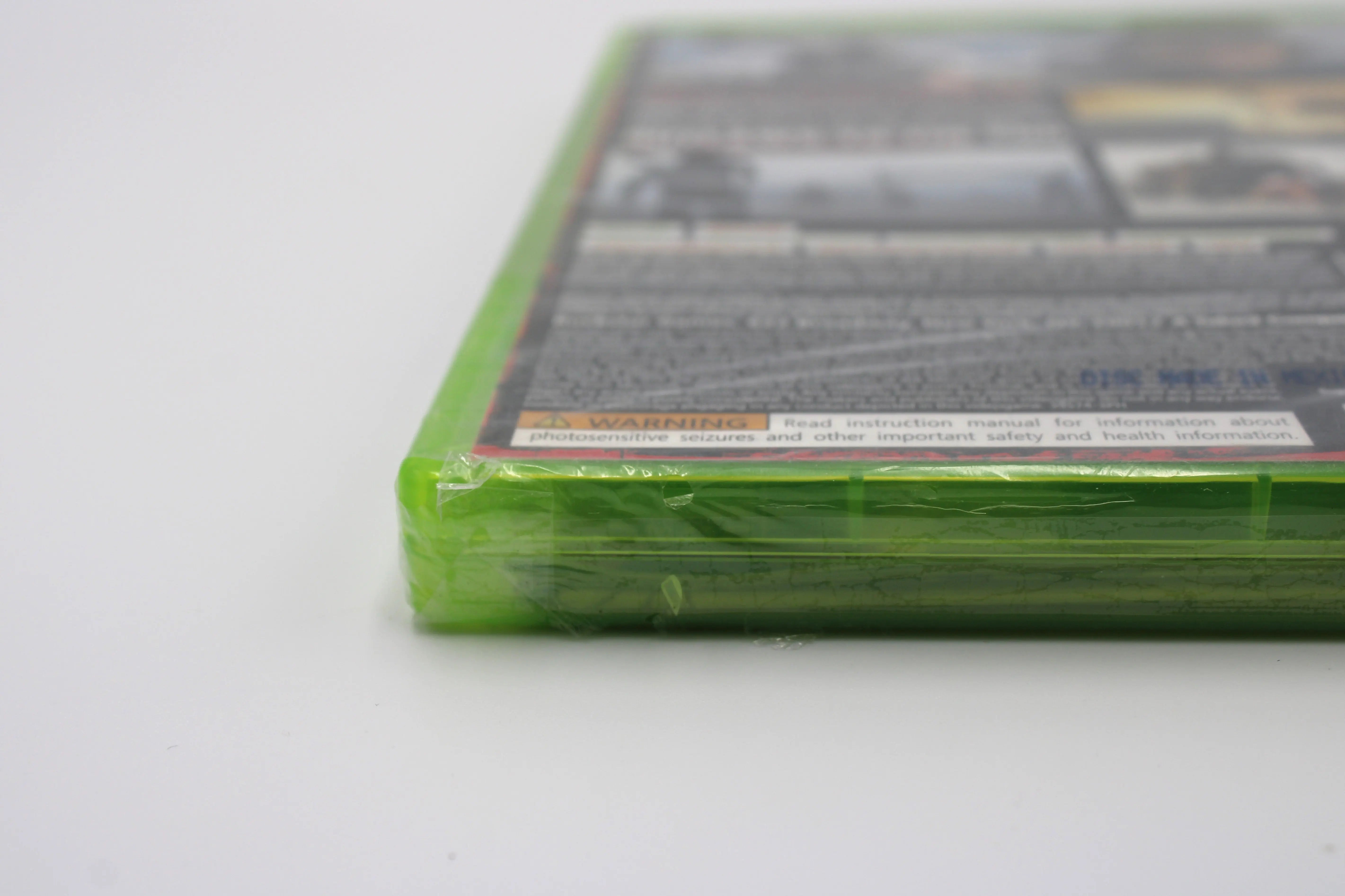 Close-up image of Red Dead Redemption for Microsoft Xbox 360 NTSC-U, showing small tear on factory seal wrap on bottom left case corner.