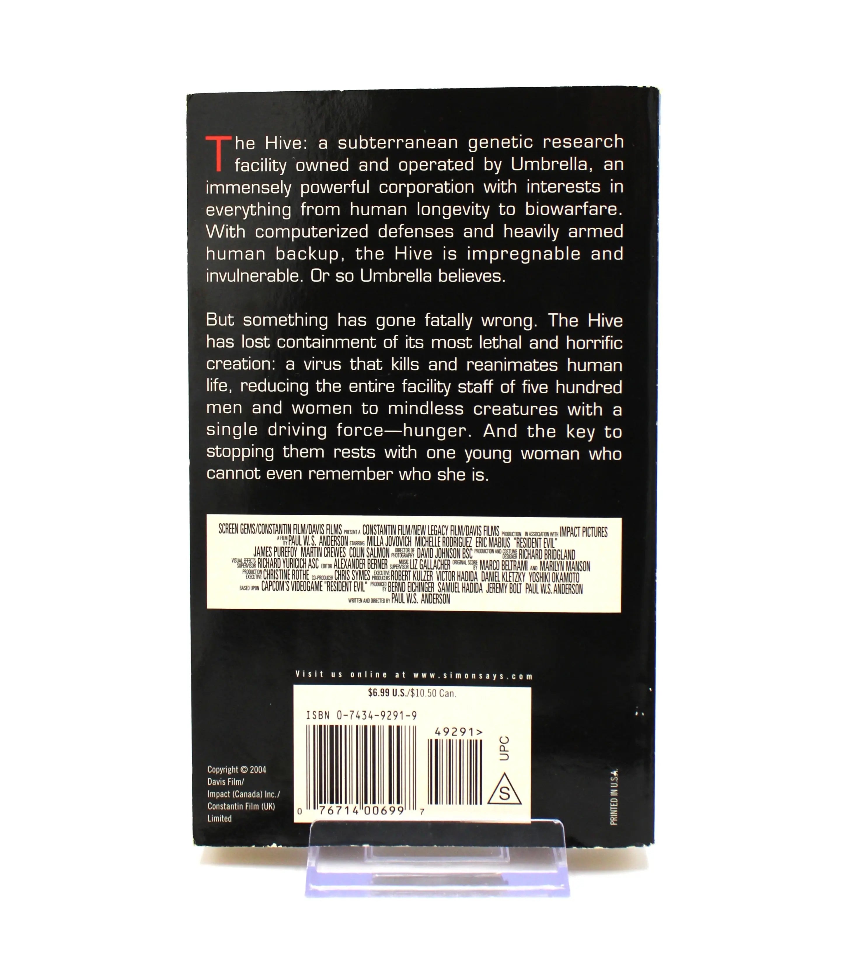 Back cover of Resident Evil: Genesis paperback – includes synopsis of Umbrella’s Hive facility outbreak. $6.99 U.S. price and ISBN 0-7434-9291-9 visible above barcode.