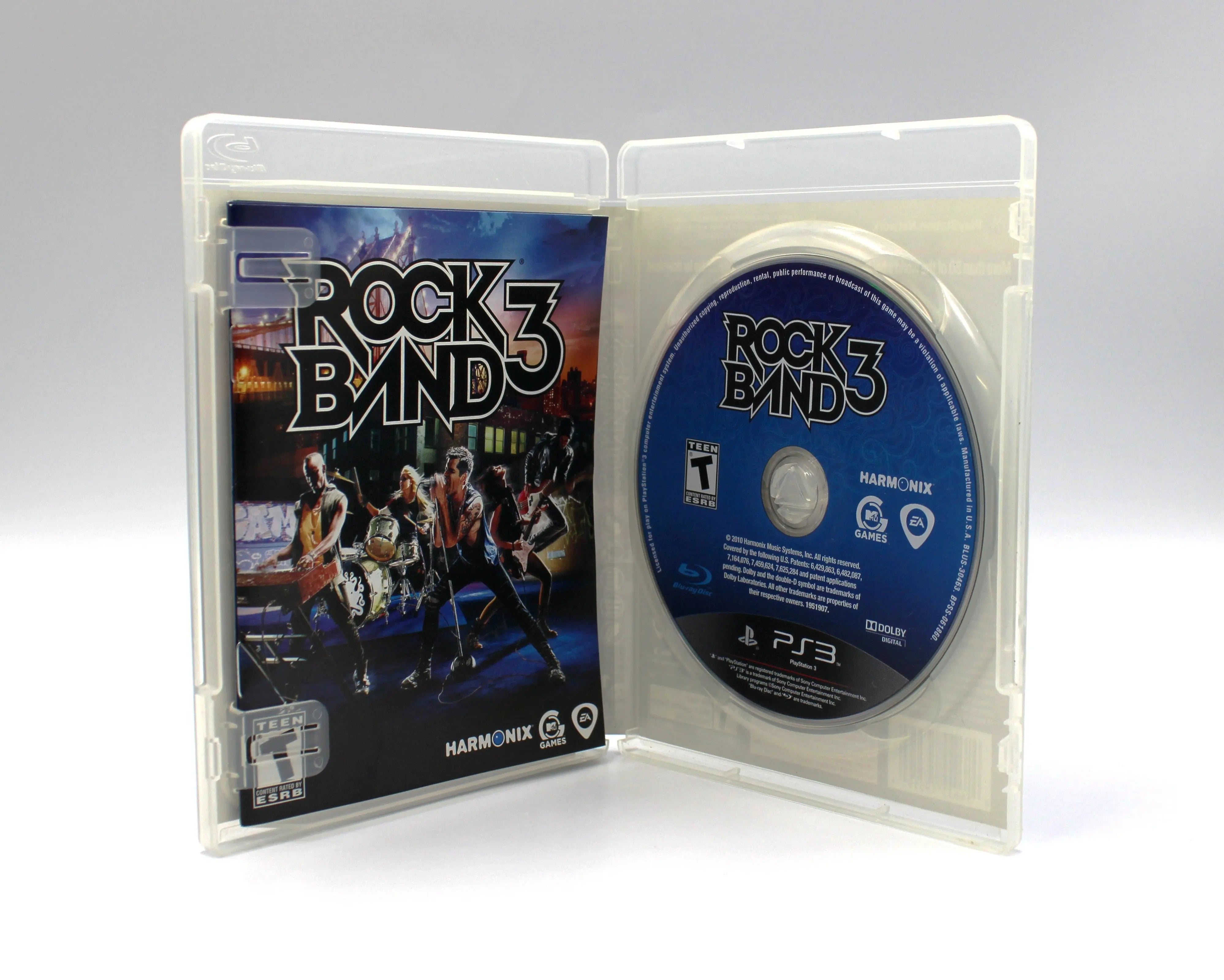 Opened case view of Rock Band 3 for Sony PlayStation 3 PS3 – Complete in Box (2010) NTSC-U. Shows manual on the left and blue Blu-ray disc on the right secured in its tray.