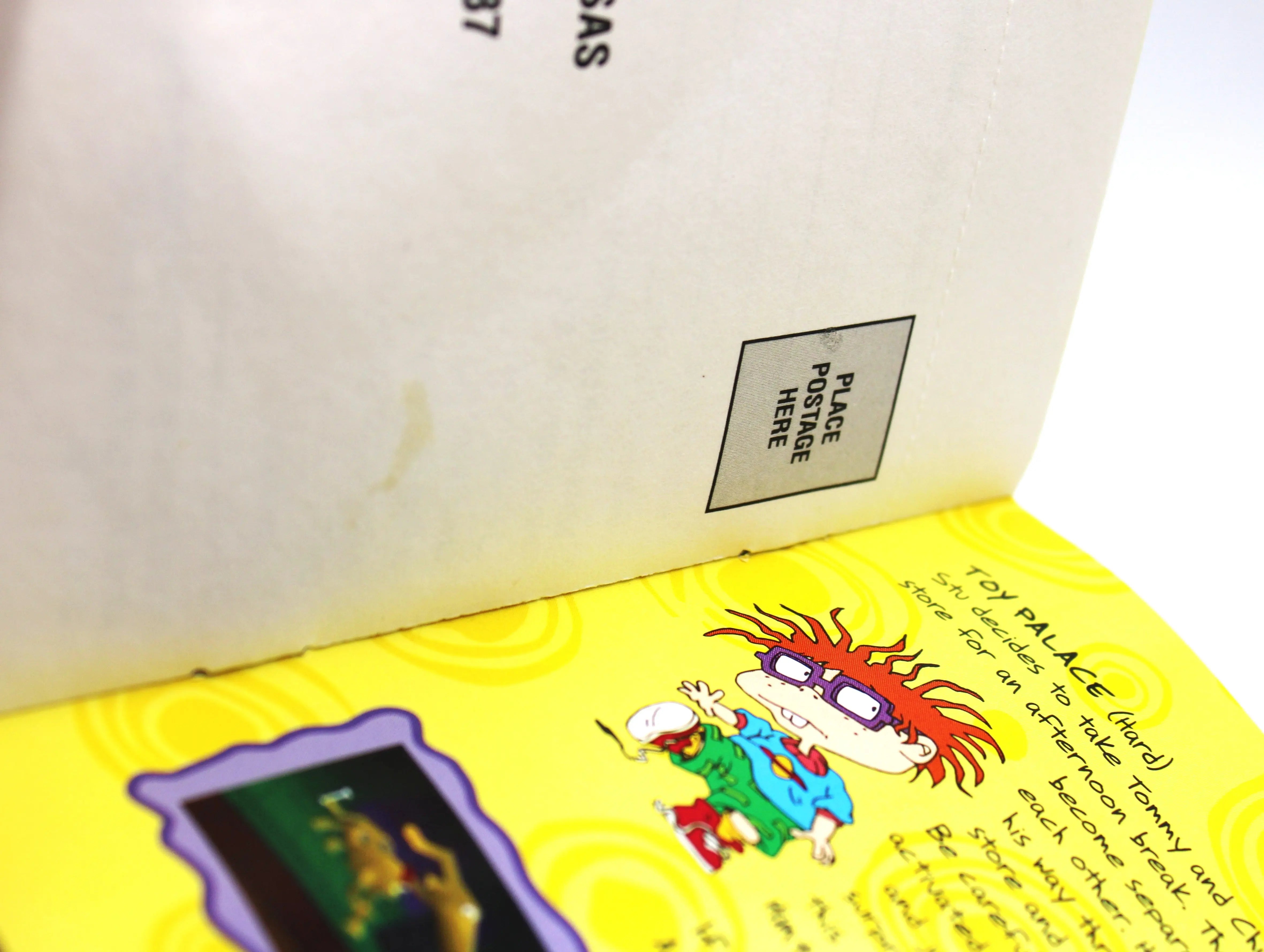 Registration card close up view: Front of the registration card for Rugrats: Search for Reptar for Sony PlayStation 1 (PS1) – CIB with Registration Card (1998) NTSC-U, black label edition, showing a small stain up close located close to the interior bind.