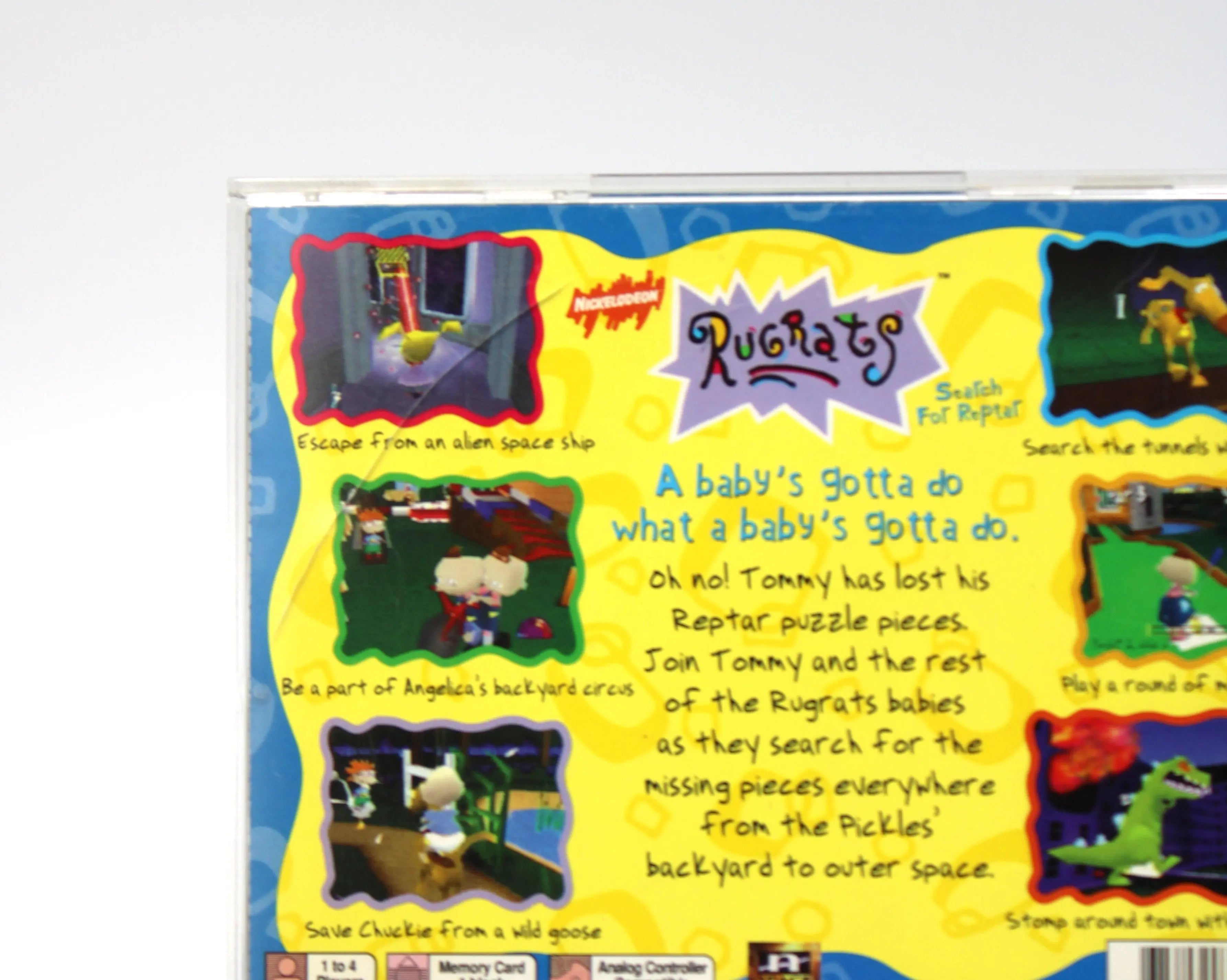 Back of case damage: Back cover view of Rugrats: Search for Reptar for Sony PlayStation 1 (PS1) – CIB with Registration Card (1998) NTSC-U, black label edition, featuring a medium-sized (approximately 2½-inch) hairline crack running along the top left of back of game case.