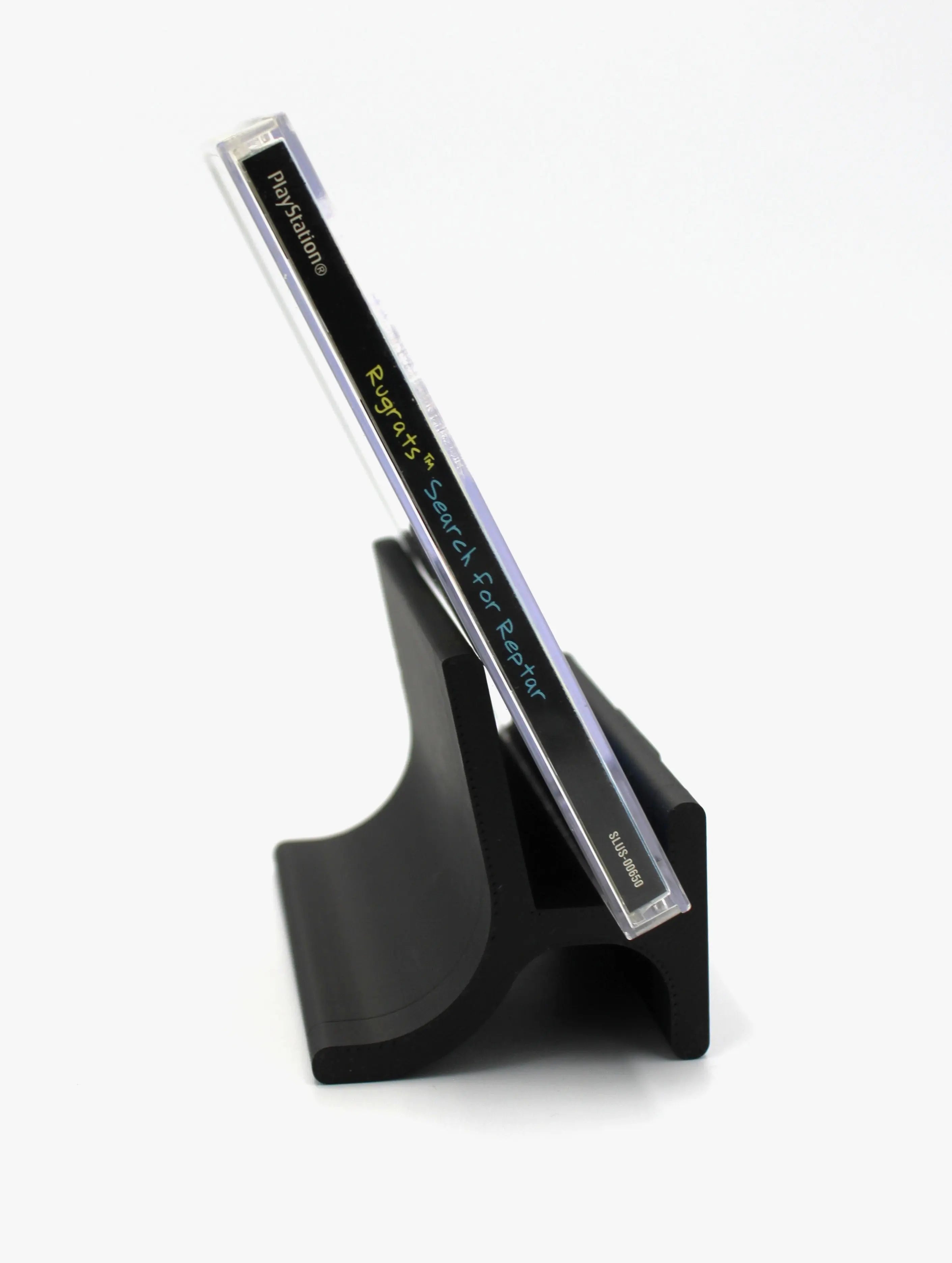 Spine: Spine view of Rugrats: Search for Reptar for Sony PlayStation 1 (PS1) – CIB with Registration Card (1998) NTSC-U, black label edition, displaying the game title and PS1 branding.