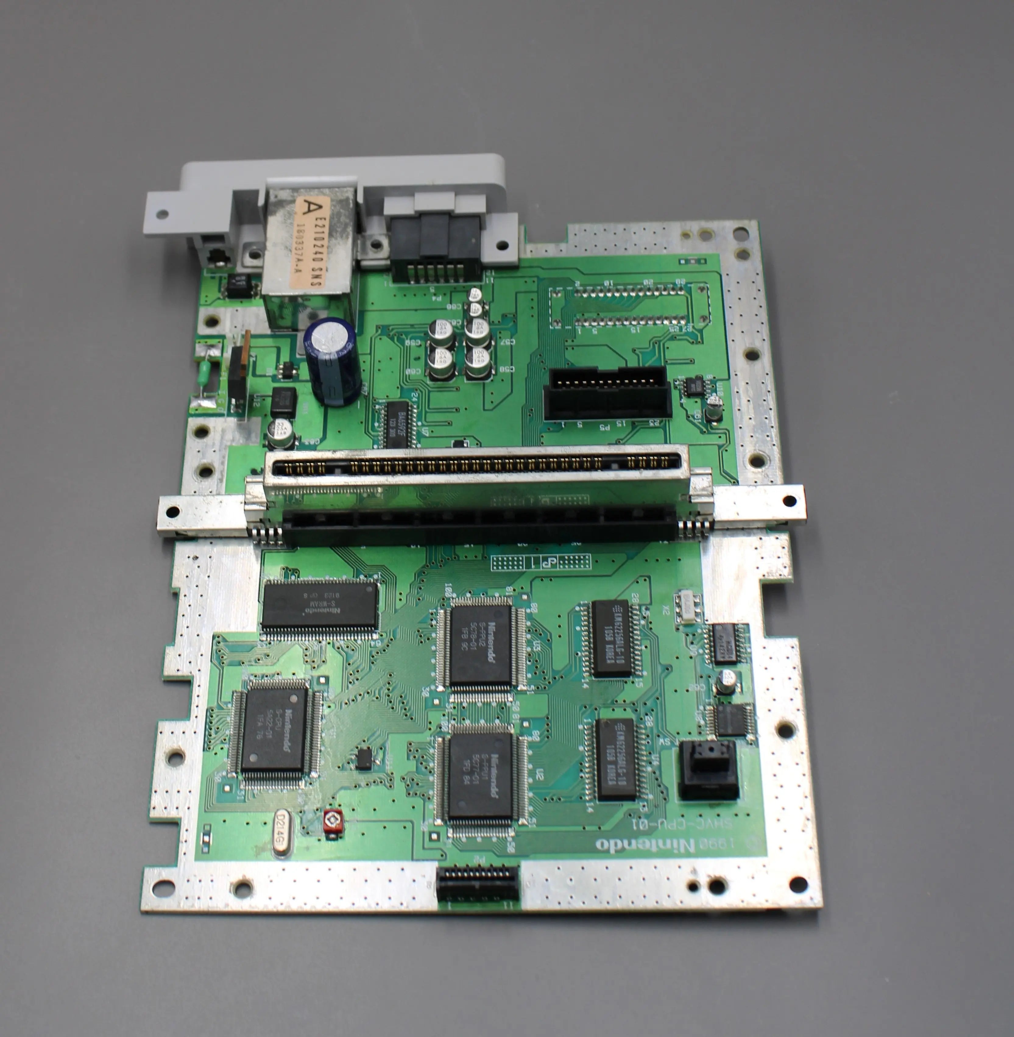 Top SNES Board View: Refurbished Super Nintendo SNES 1991 NTSC-U system with a new red shell motherboard. Image of top of SNES board showing restoration process and clean chips and parts.