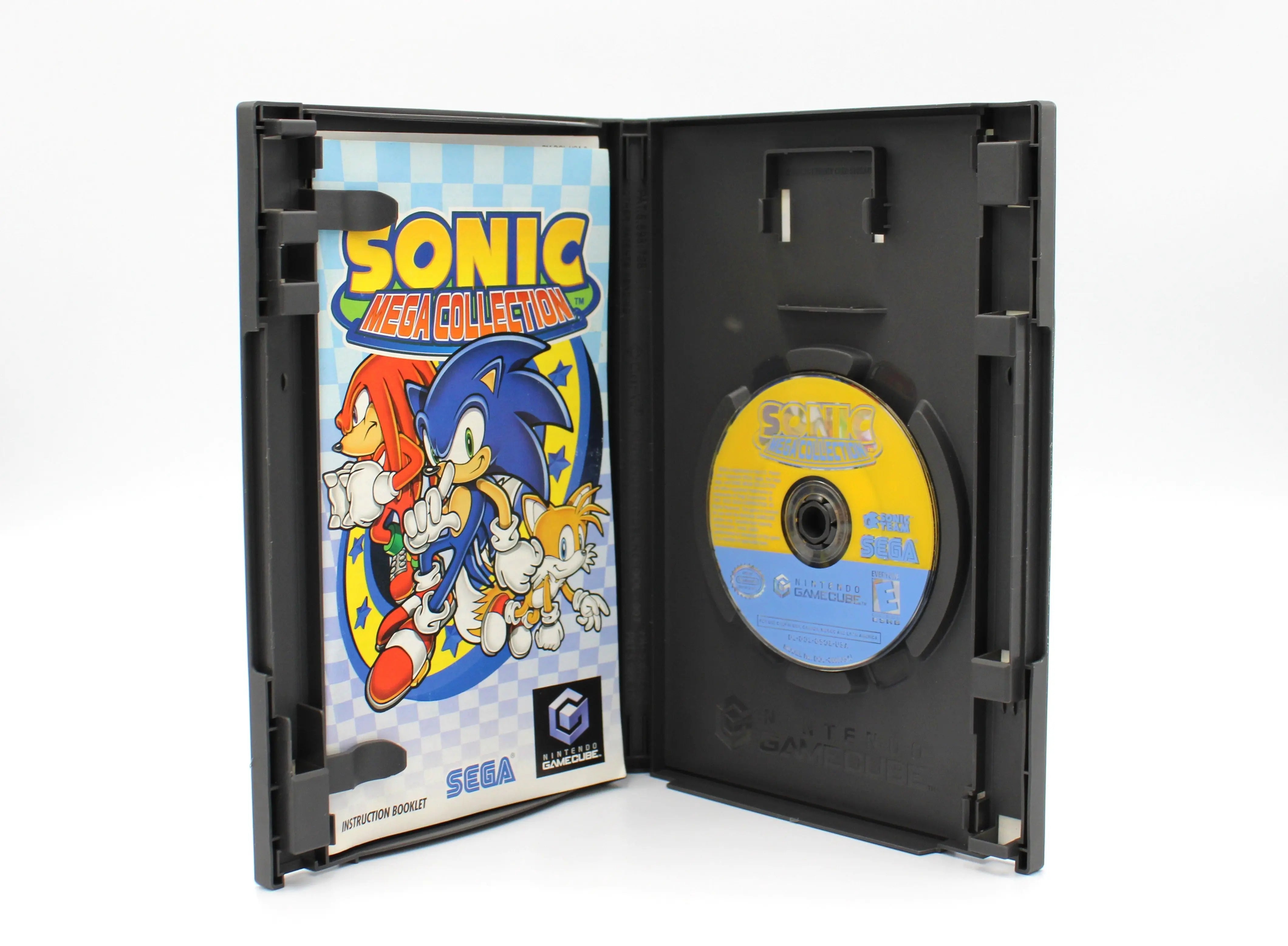 “Opened case of Sonic Mega Collection for Nintendo GameCube – NTSC‑U black label CIB with Manual (2002), revealing the disc seated in its hub and the instruction manual inserted in the interior sleeve.”
