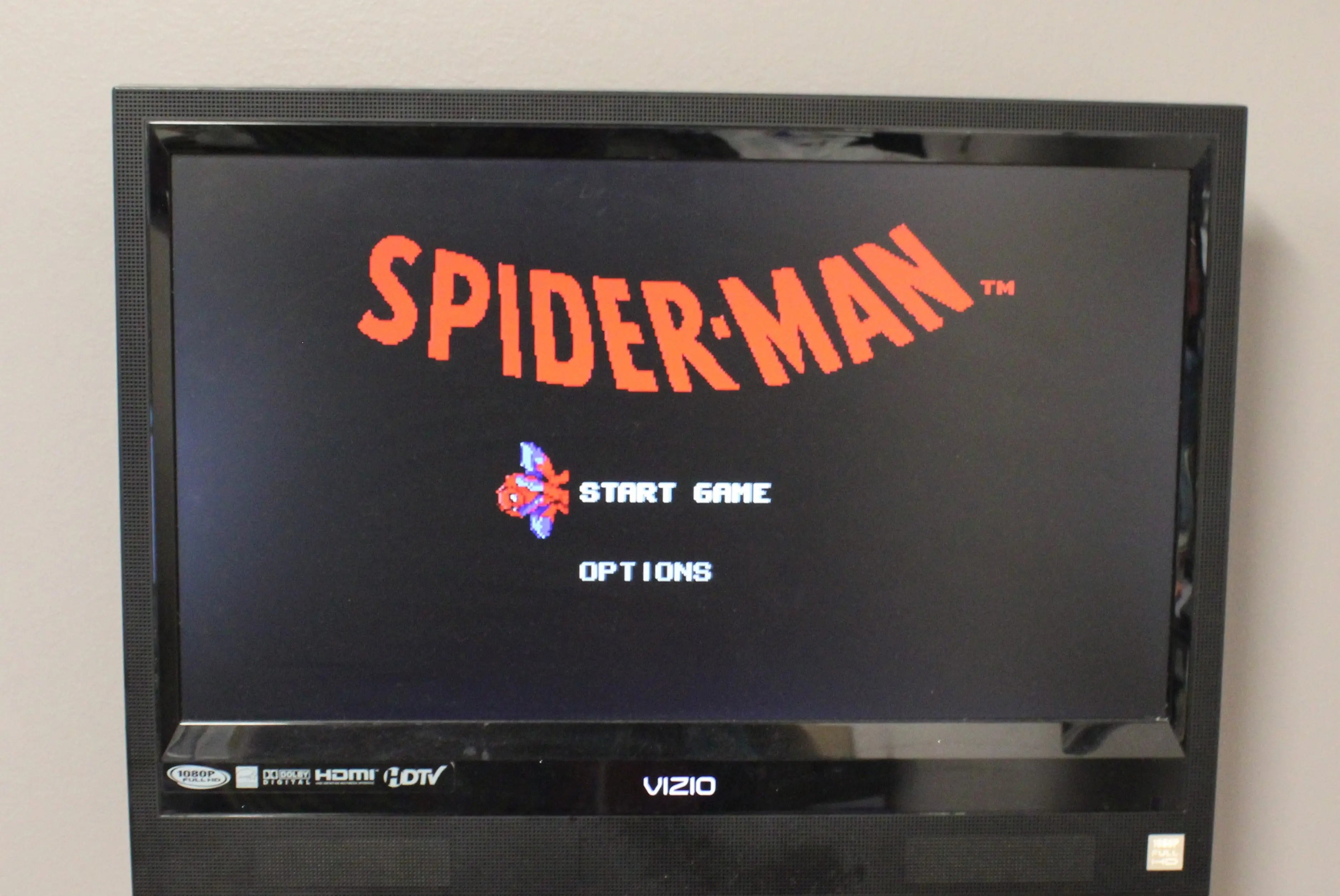 Title screen of Spider‑Man for Sega Genesis – Authentic Game Cartridge (1991), displaying the red Spider‑Man logo with an Options and “Press Start” prompt.