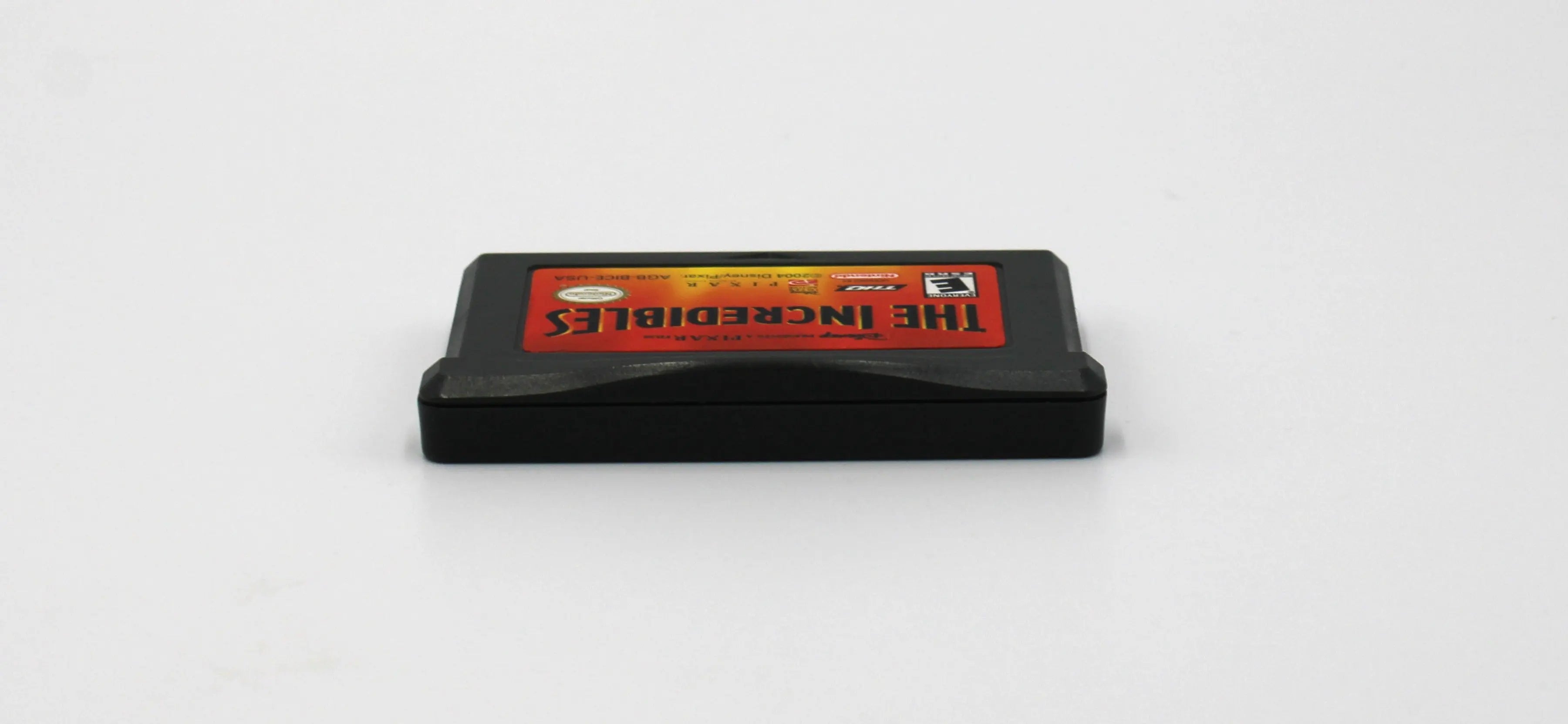 Top edge view of The Incredibles for Nintendo Game Boy Advance GBA – Authentic Game Cartridge (2004) NTSC‑U, showing clean alignment of shell halves and label edge.