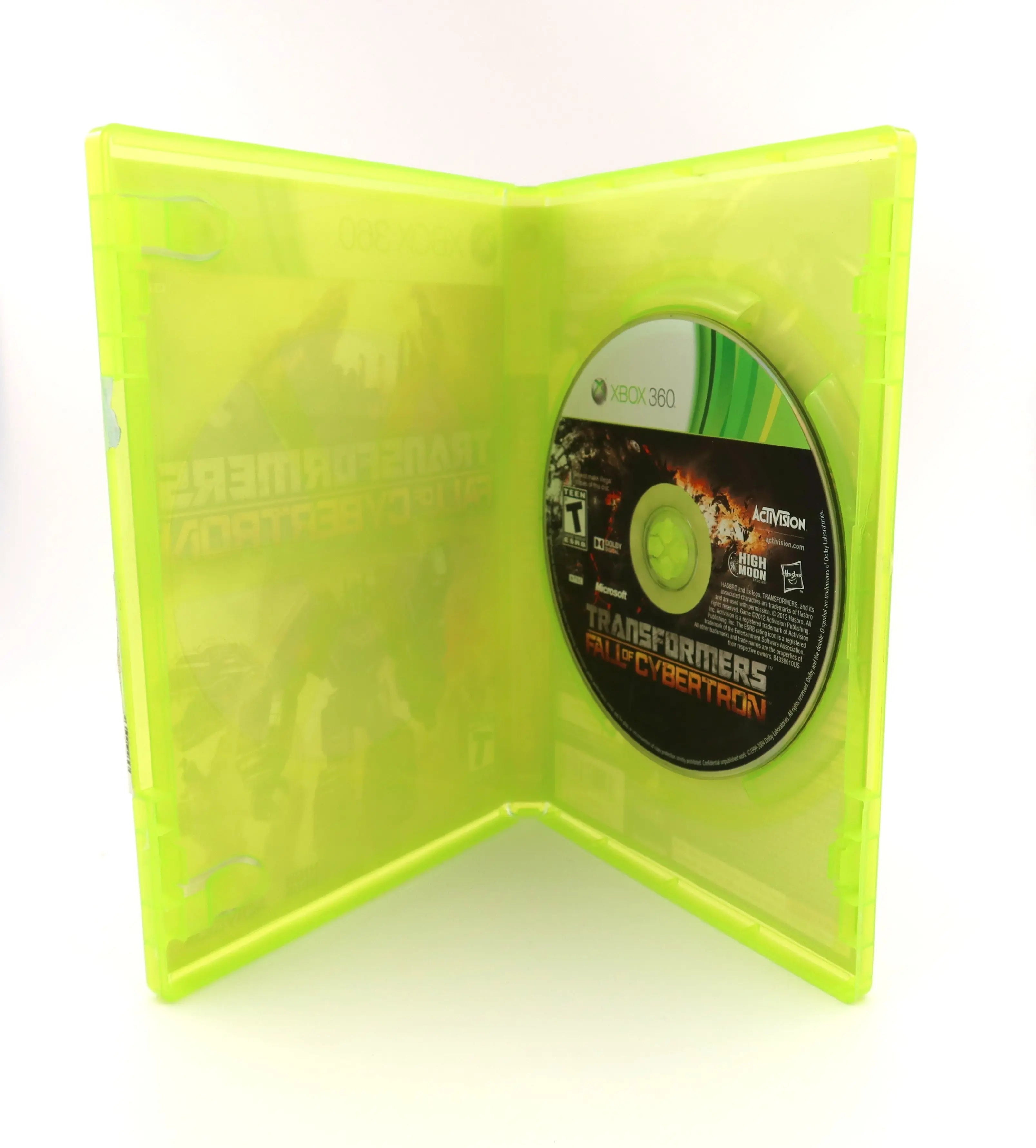 Opened case view of Transformers: Fall of Cybertron for Microsoft Xbox 360 (2012) NTSC-U, showing original game disc secured inside the OEM green Xbox 360 case. No manual is included.