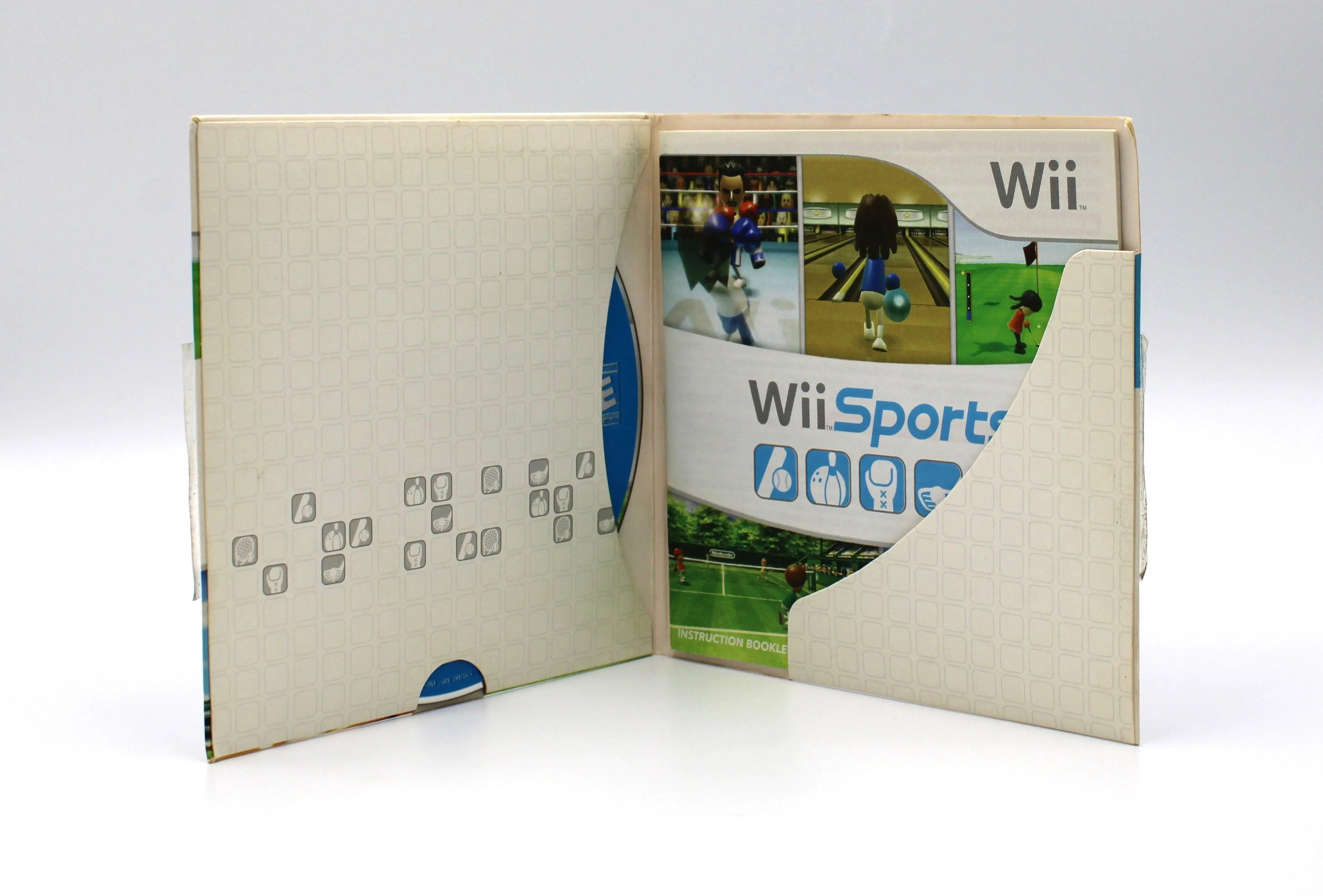 Opened case view of an 2006 NTSC-U copy of Wii Sports for Nintendo Wii showcasing cardboard sleeve opened with manual and disc secure against a clean white background.