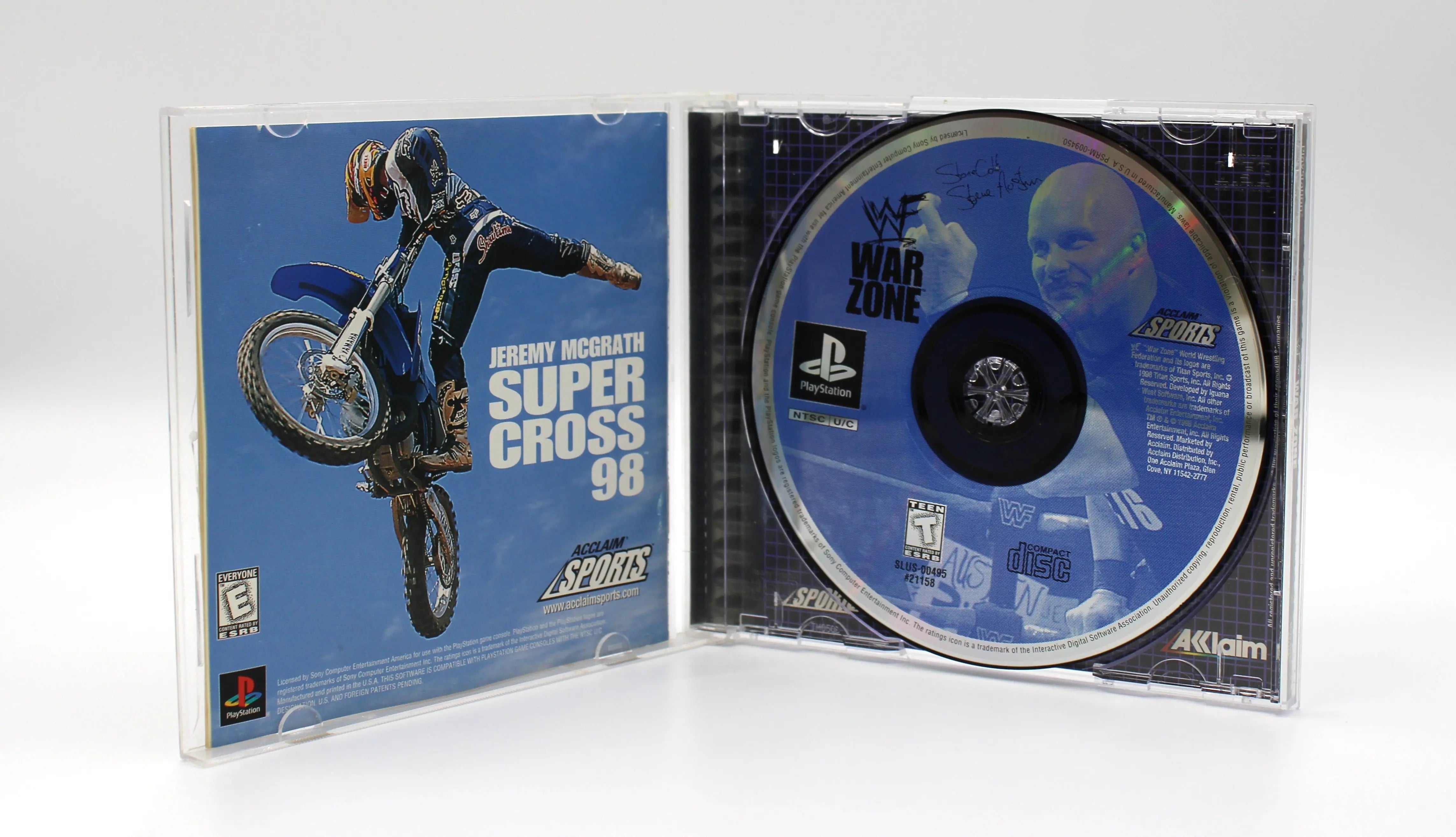 Open case view of black label North American NTSC copy of the black label variant WWF War Zone for the Sony PlayStation 1. Registration card is intact to the front manual instruction booklet. Disc is clean and authentic. Booklet is intact. Case is clean. Displayed on a white background.